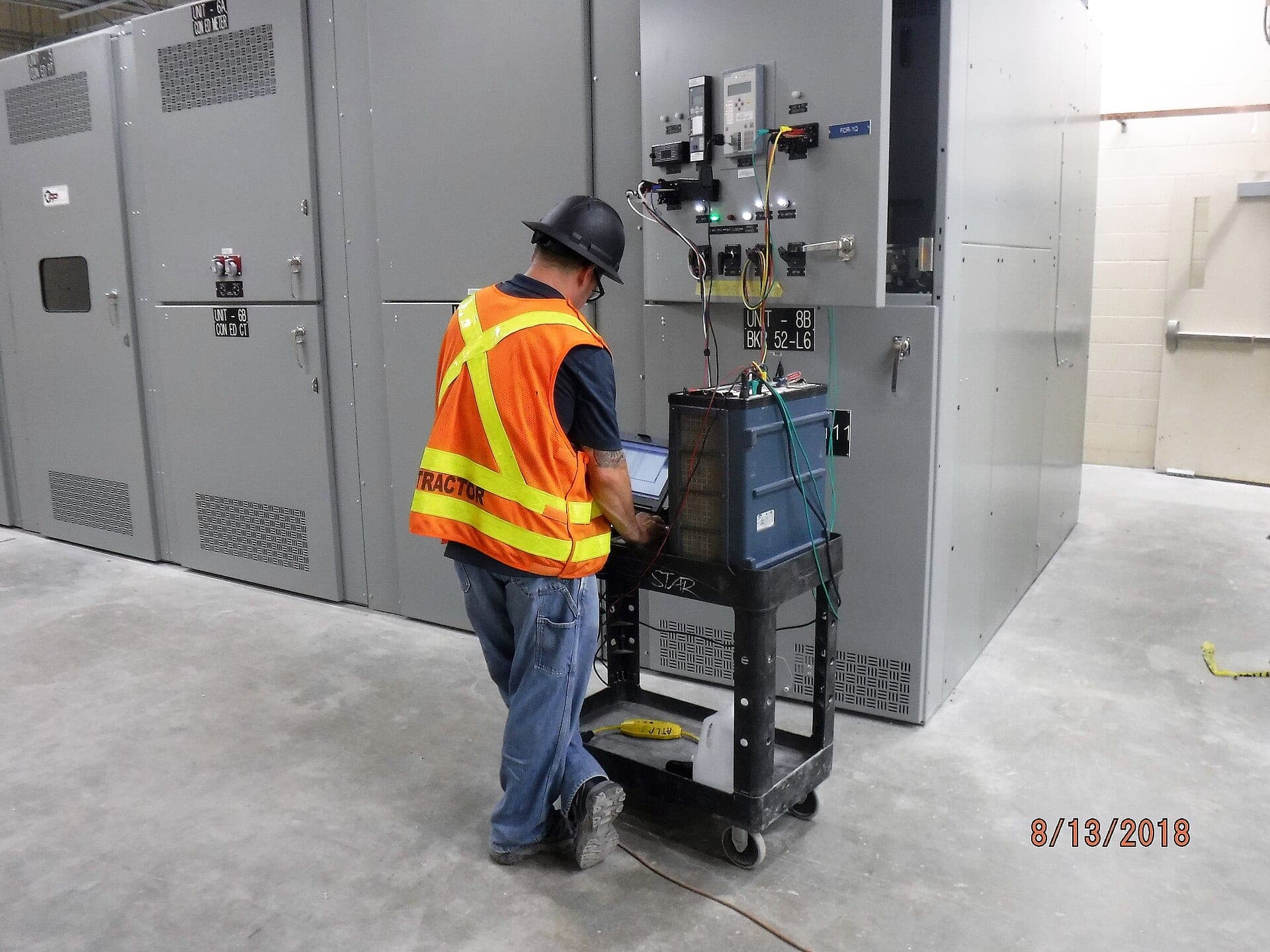 Engineer testing switchgear equipment in a power substation