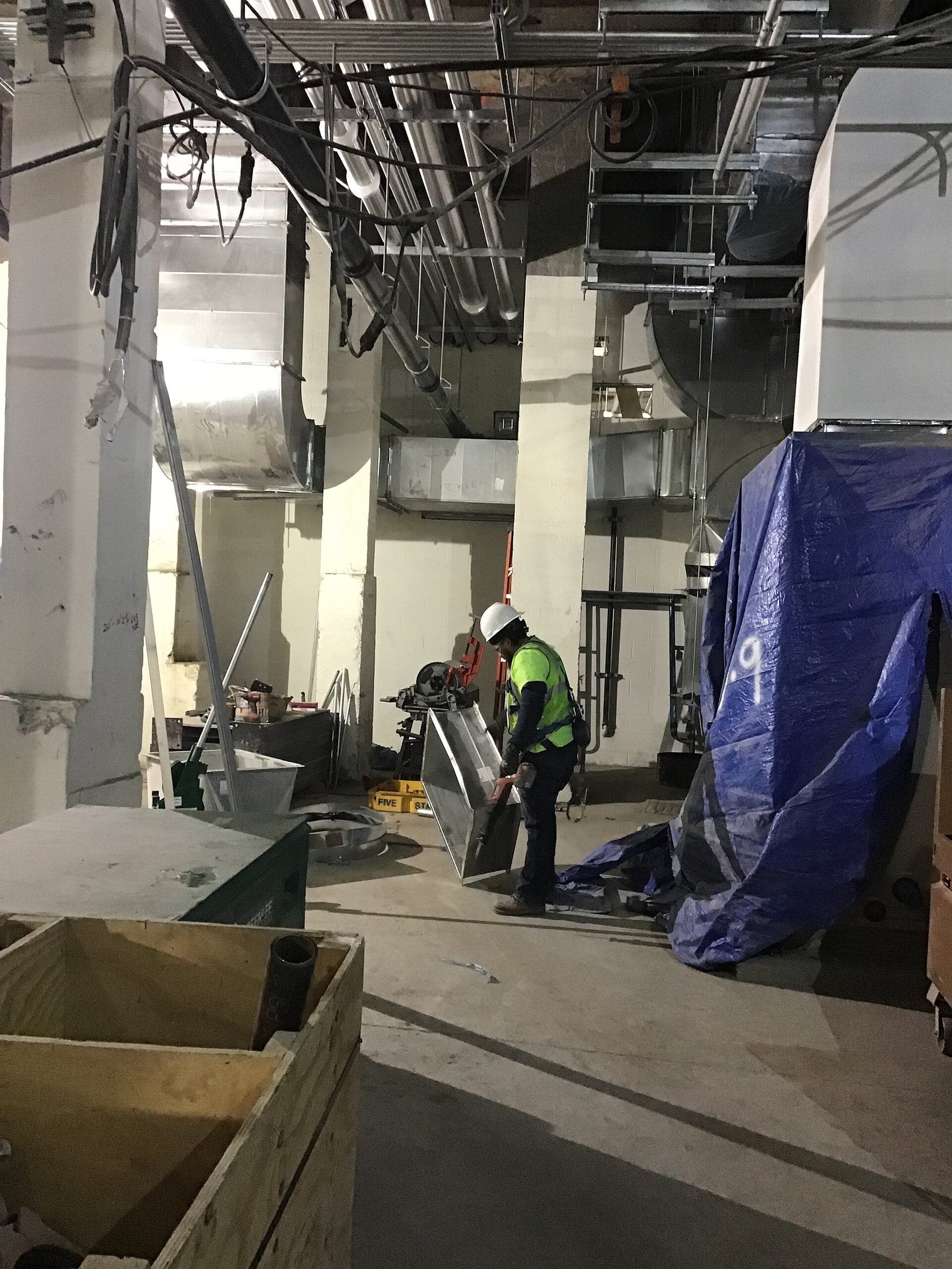 Mechanical room with HVAC ductwork and piping during installation